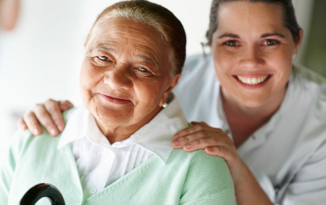 closeup_white_nurse_with_hands_on_elderly_patients_shoulders_smiling