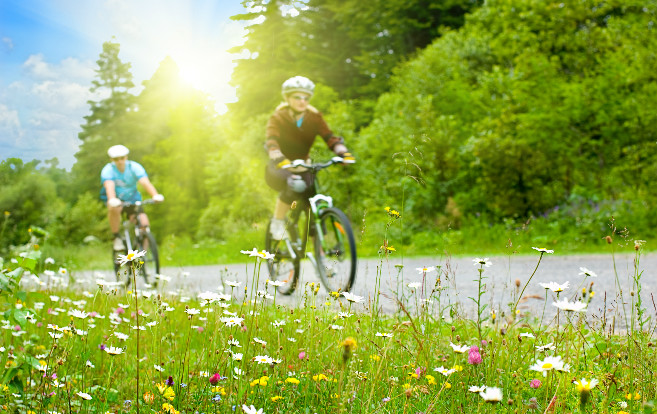 two_people_on_bikes_spring_exercise_couple_flowers