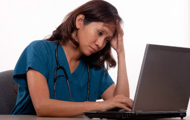 tired_ethnic_nurse_head_hanging_looking_at_computer