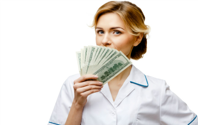white_blonde_nurse_holding_hundred_dollar_bills_fanned_in_front_face